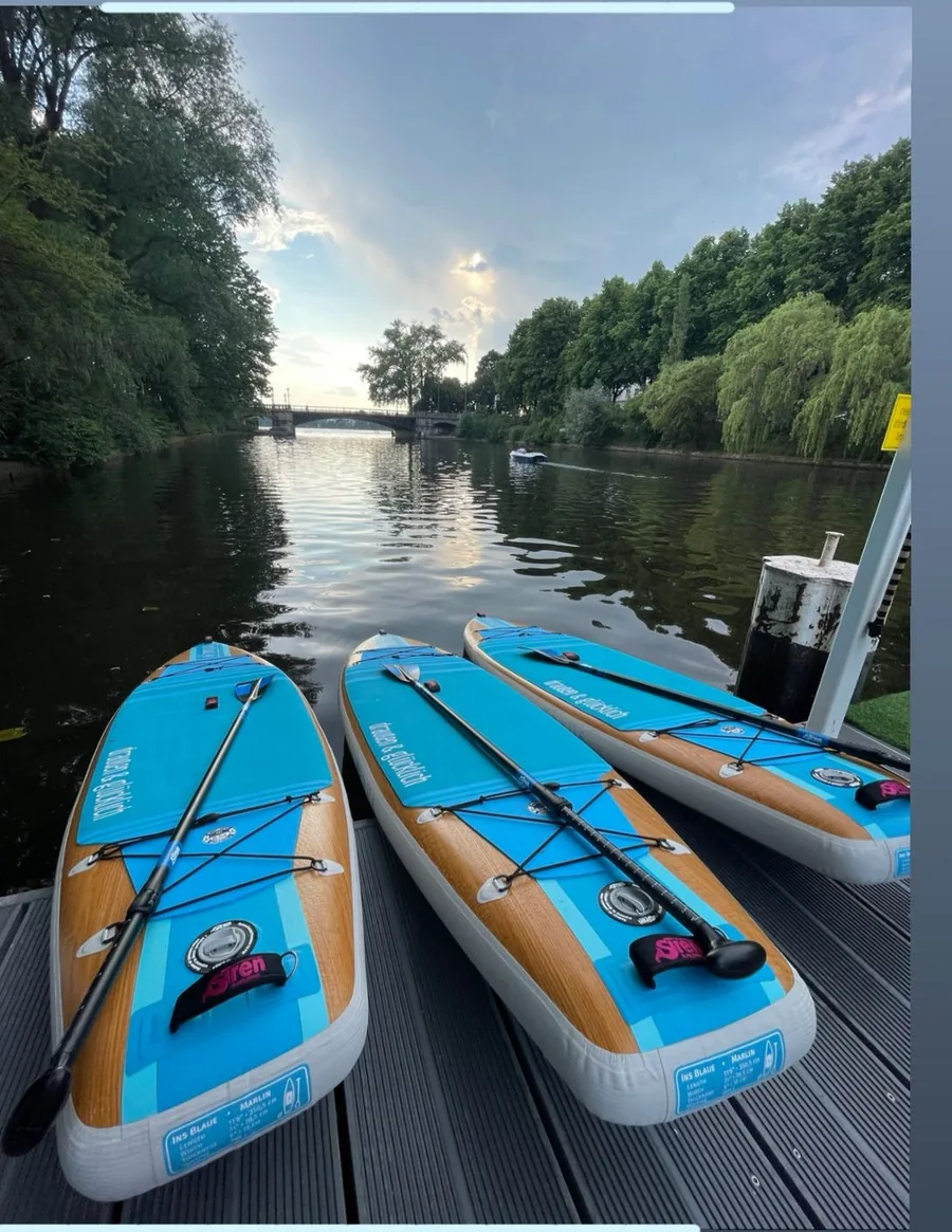 Drei Boards liegen auf dem Steg, dahinter der Kanal