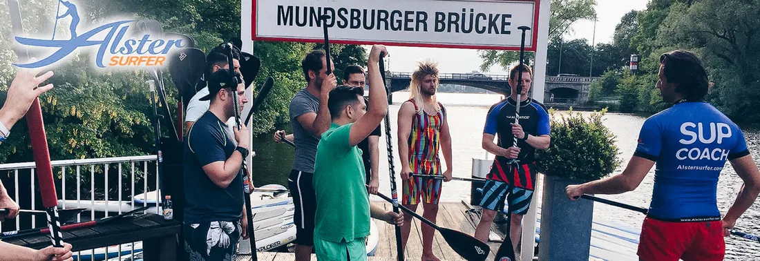 Gruppe mit Paddeln unter dem Schild Mundsburger Brücke