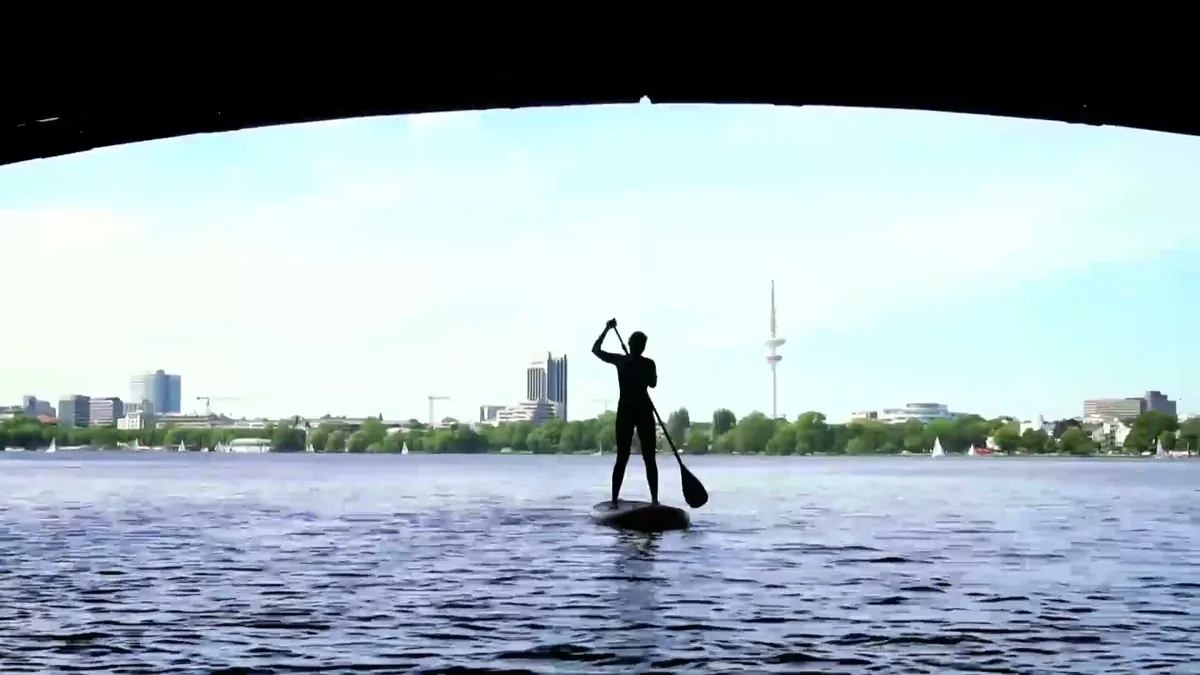 Paddler unter der Mundsburger Brücke mit Blick auf die Skyline